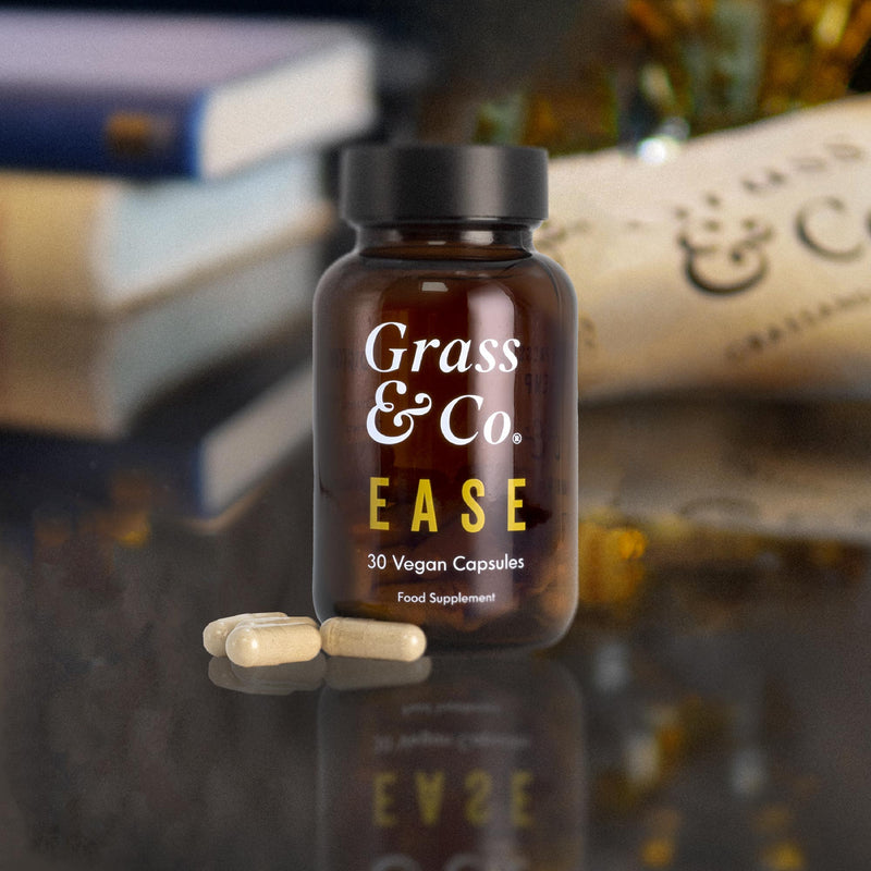 EASE CBD capsules bottle with 3 capsules in front of it.